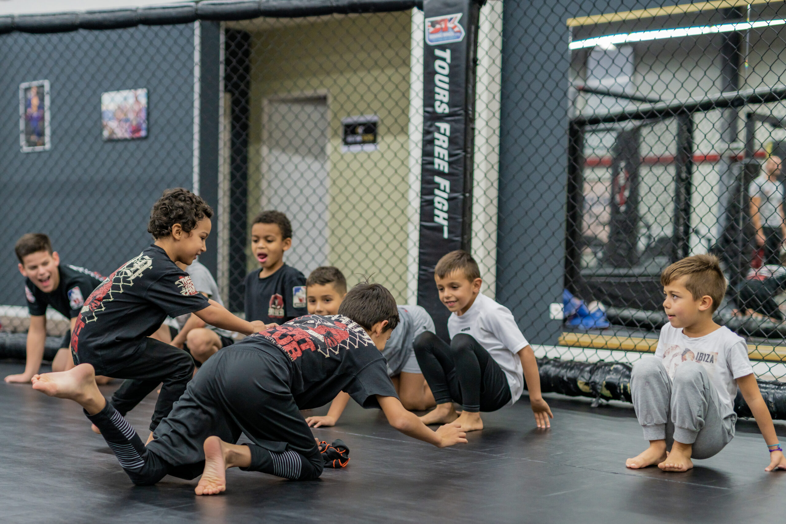 Enfants participant à un exercice collectif sur le tatami du MMA Fight Club Gym